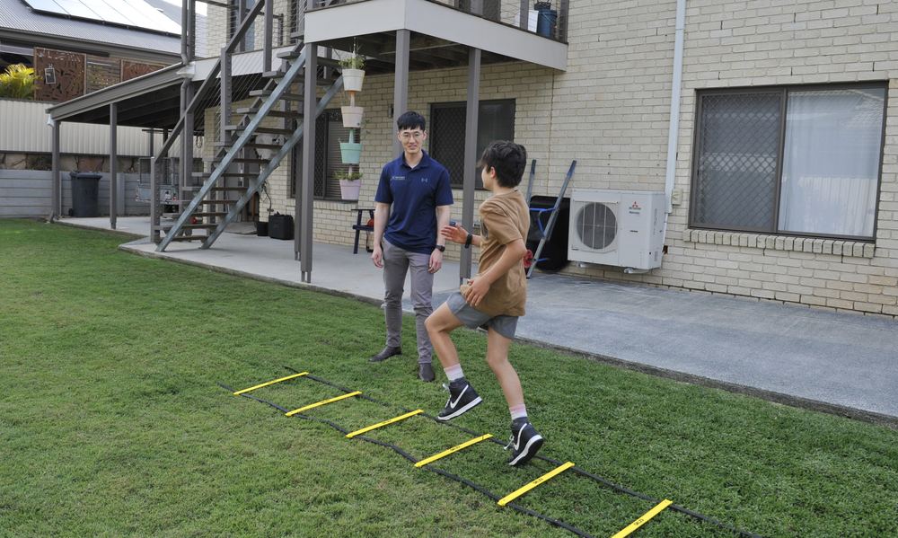 Physiotherapist supporting a child with a movement activity