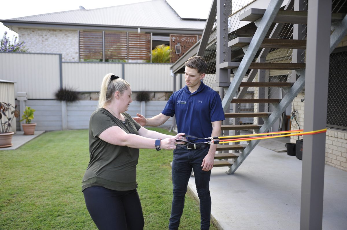 Physiotherapist supporting post-hospital rehabilitation at home